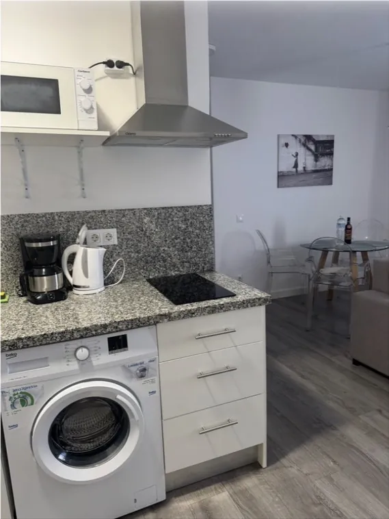 Cocina abierta con lavadora y electrodomésticos
