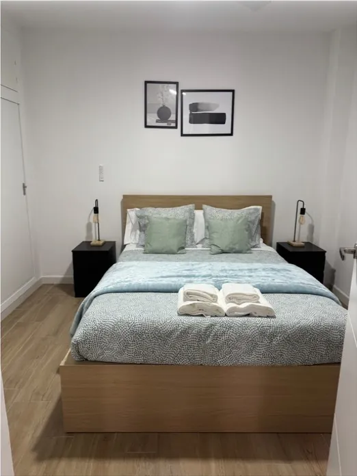 Dormitorio ordenado con mesitas y lámparas