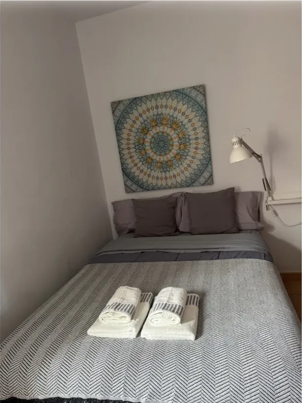 Dormitorio con cama de matrimonio y toallas dobladas